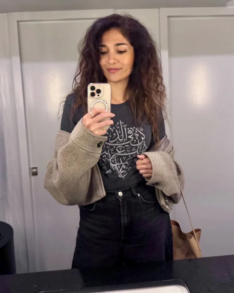 A woman wearing the Be in This World Like a Traveler tee